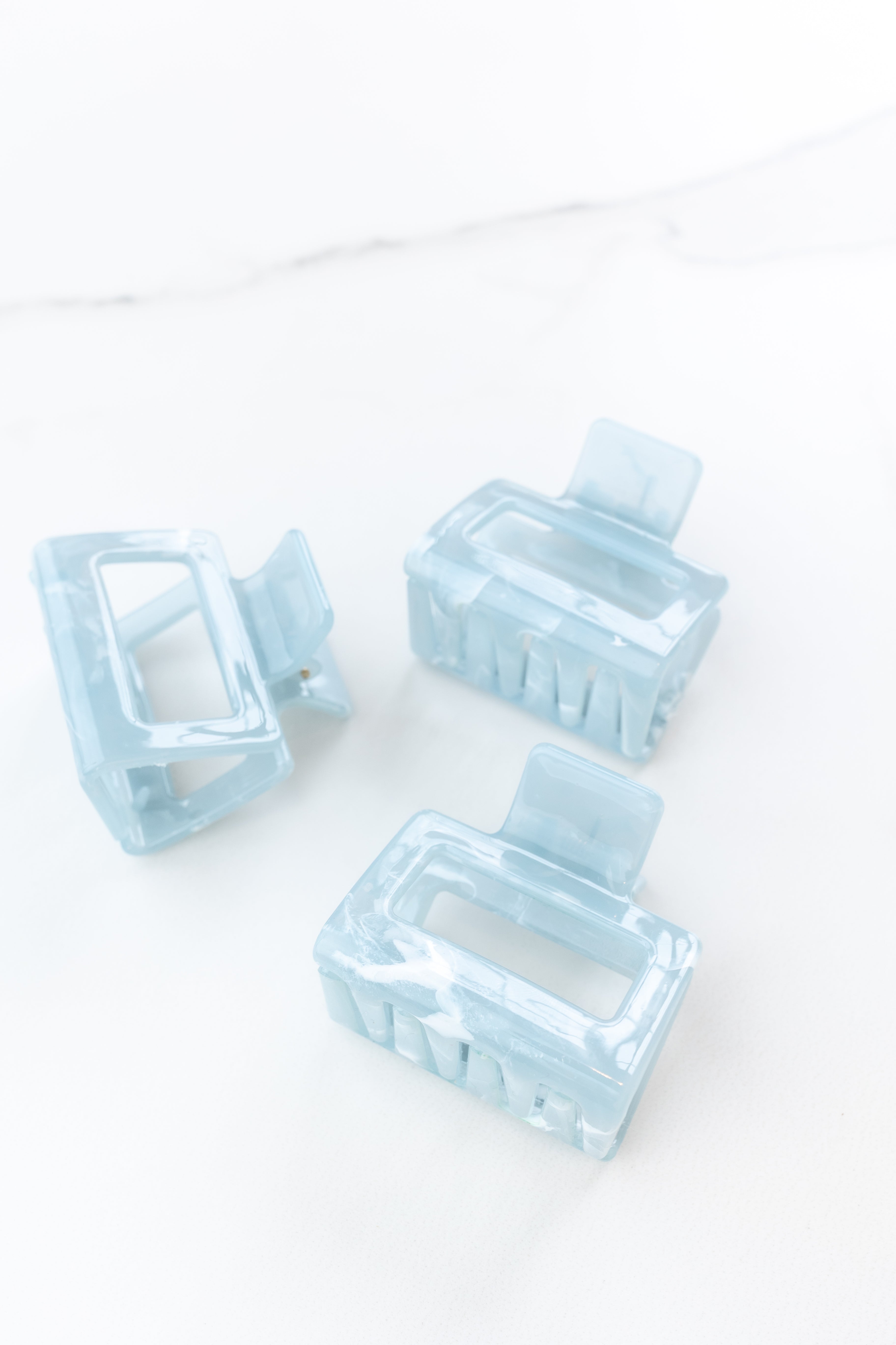 Spring Fling Lilac Clip featuring an opaque square blue clip, 2 inches long, glossy material, metal hinge closure, ideal for keeping hair styled and out of your face.