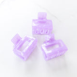 Spring Fling Lilac Clip featuring an opaque square purple clip, 2 inches long, glossy material, metal hinge closure, ideal for keeping hair styled and out of your face.