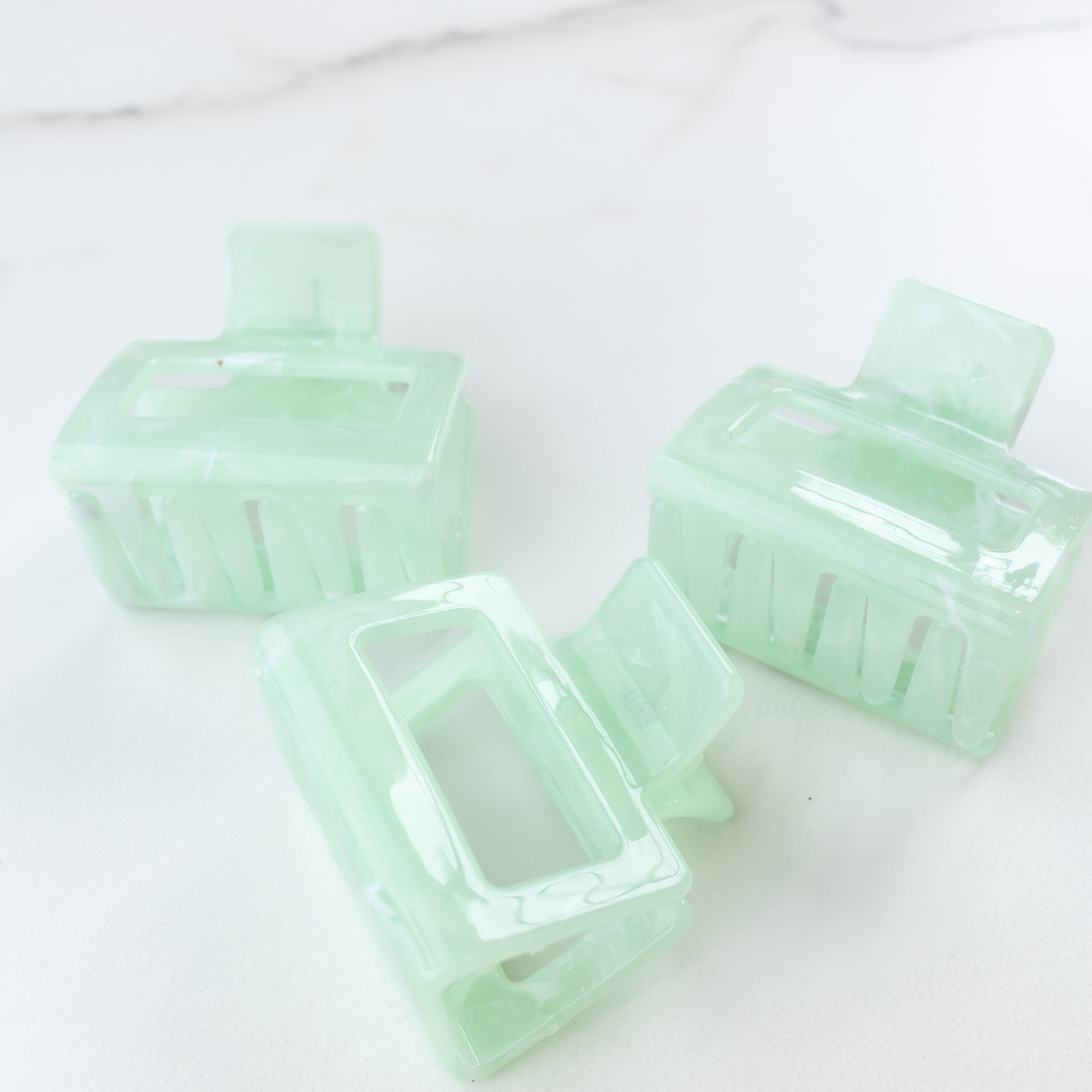 Spring Fling Lilac Clip featuring an opaque square green clip, 2 inches long, glossy material, metal hinge closure, ideal for keeping hair styled and out of your face.