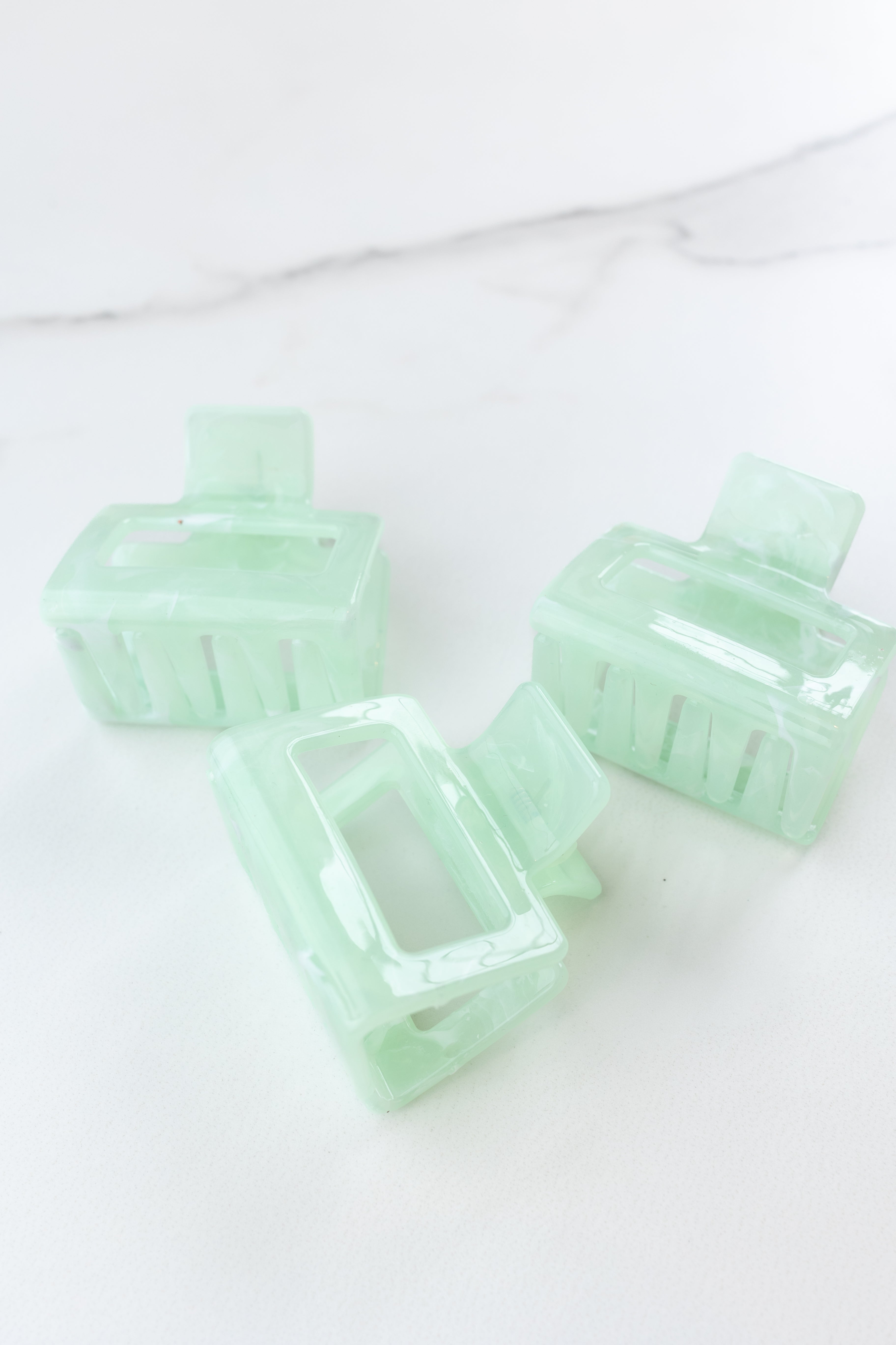 Spring Fling Lilac Clip featuring an opaque square green clip, 2 inches long, glossy material, metal hinge closure, ideal for keeping hair styled and out of your face.
