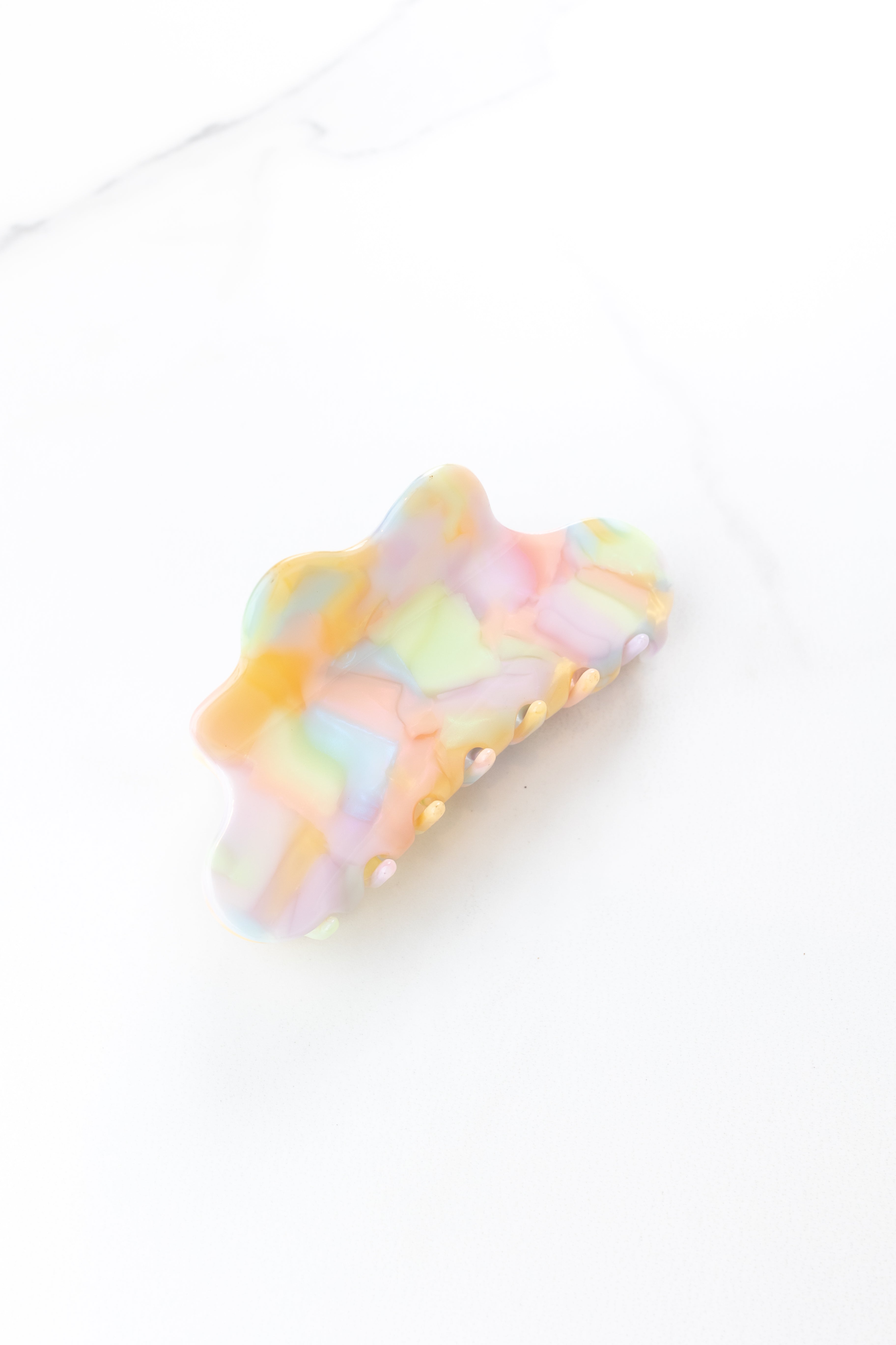 On Cloud 9 Lilac Clip featuring a pastel watercolor pattern with purple, orange, coral, green and blue, 4 inches long, glossy material, metal hinge closure, ideal for keeping hair styled and out of your face.