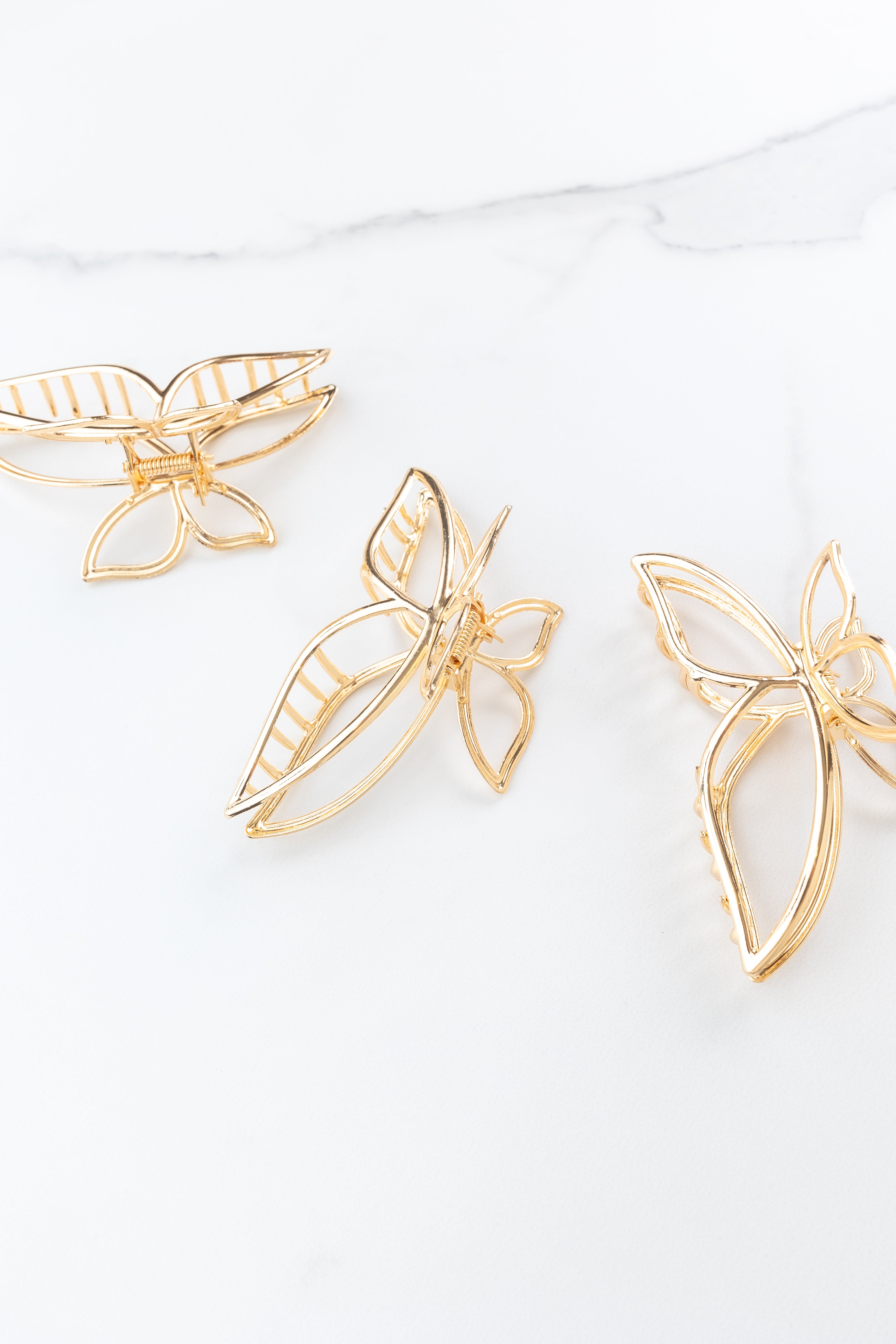 Butterfly Kisses Lilac Clip featuring gold butterfly wing shape, 4 inches long, metal material, hinge closure, ideal for keeping hair styled and out of your face.