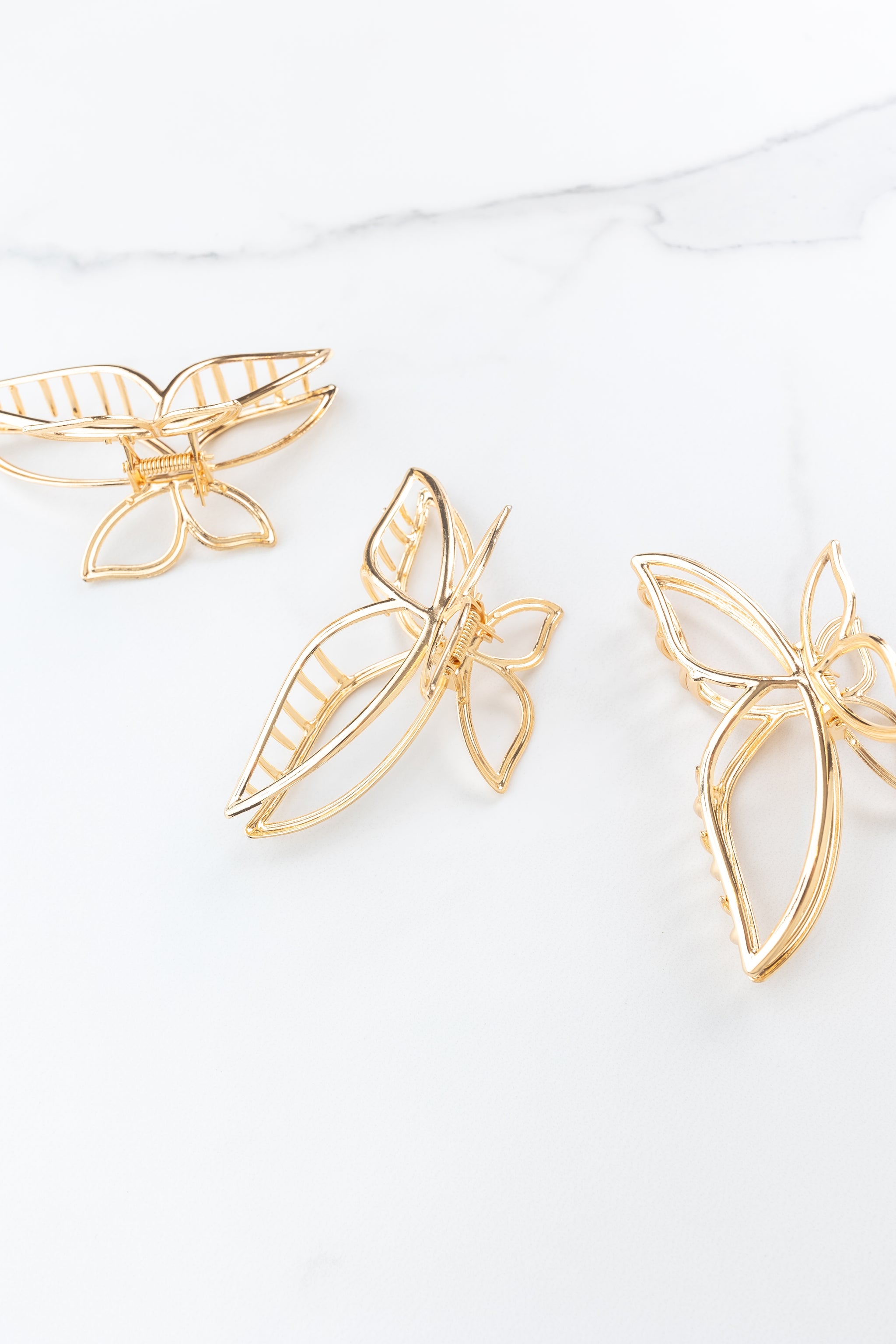 Butterfly Kisses Lilac Clip featuring gold butterfly wing shape, 4 inches long, metal material, hinge closure, ideal for keeping hair styled and out of your face.