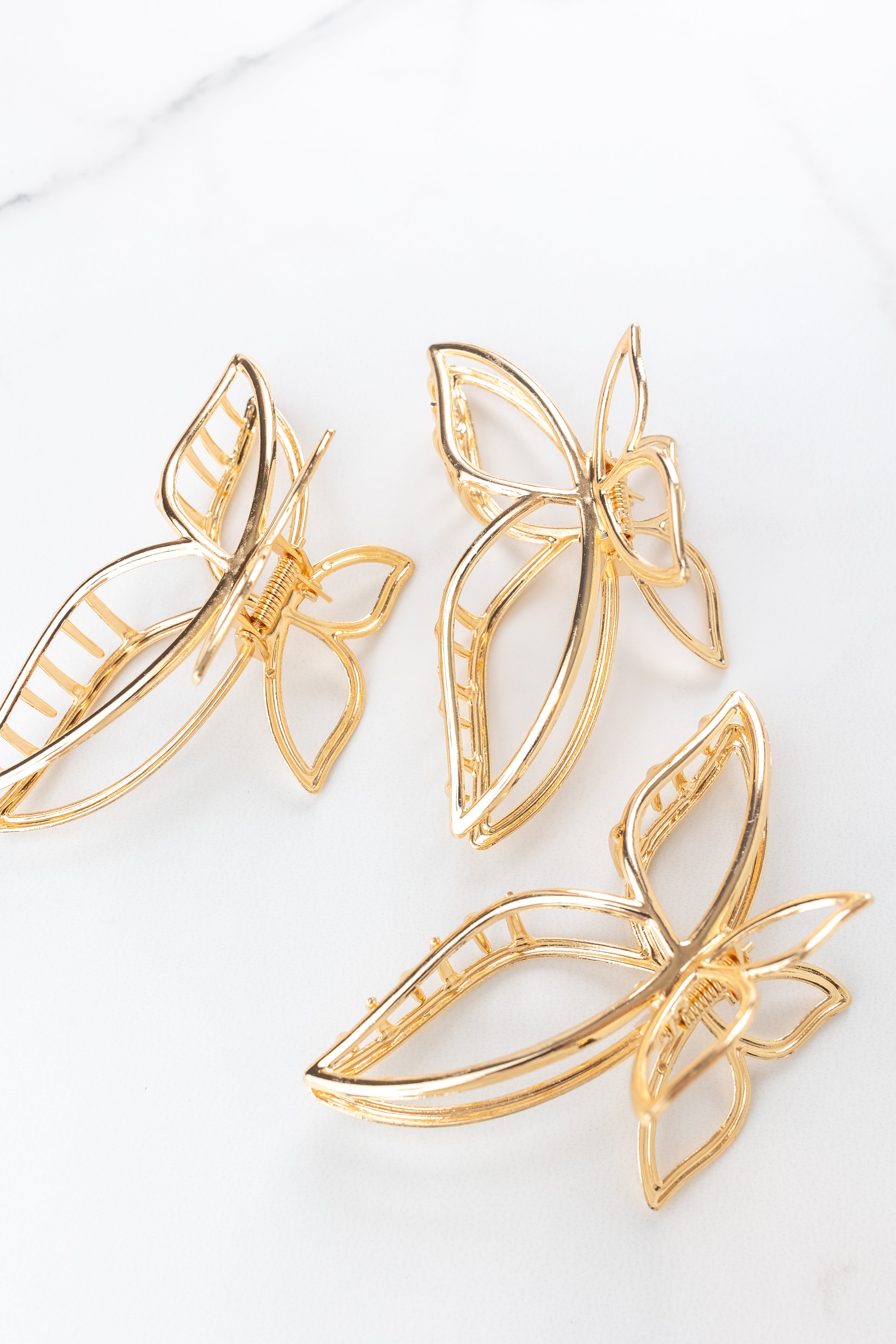 Butterfly Kisses Lilac Clip featuring gold butterfly wing shape, 4 inches long, metal material, hinge closure, ideal for keeping hair styled and out of your face.