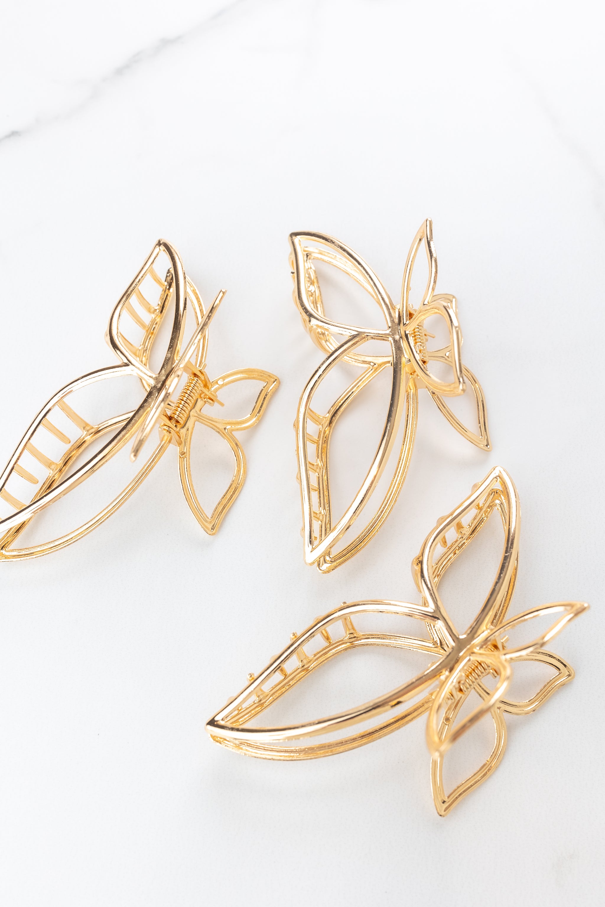 Butterfly Kisses Lilac Clip featuring gold butterfly wing shape, 4 inches long, metal material, hinge closure, ideal for keeping hair styled and out of your face.