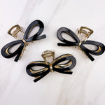 Treat Yourself Lilac Clip, a glossy 4-inch claw clip with hinge closure, available in two color options of white or black, perfect for keeping hair in place.