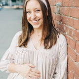 Woman smiling, wearing Preston Floral on Ivory headband from The Sarah Wallace Collection, showcasing its soft, stretchy fabric and versatile 3-in-1 twist style.