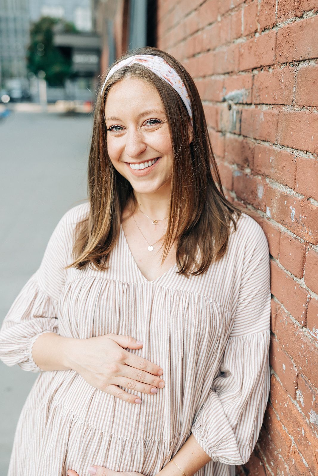 Woman smiling, wearing Preston Floral on Ivory headband from The Sarah Wallace Collection, showcasing its soft, stretchy fabric and versatile 3-in-1 twist style.