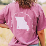 Adult berry colored shirt with Missouri state with the words "Handcrafted with Love in Springfield, MO" over the back, and "Lilac Market in script in the front with the outline of the setting sun