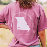 Adult berry colored shirt with Missouri state with the words "Handcrafted with Love in Springfield, MO" over the back, and "Lilac Market in script in the front with the outline of the setting sun