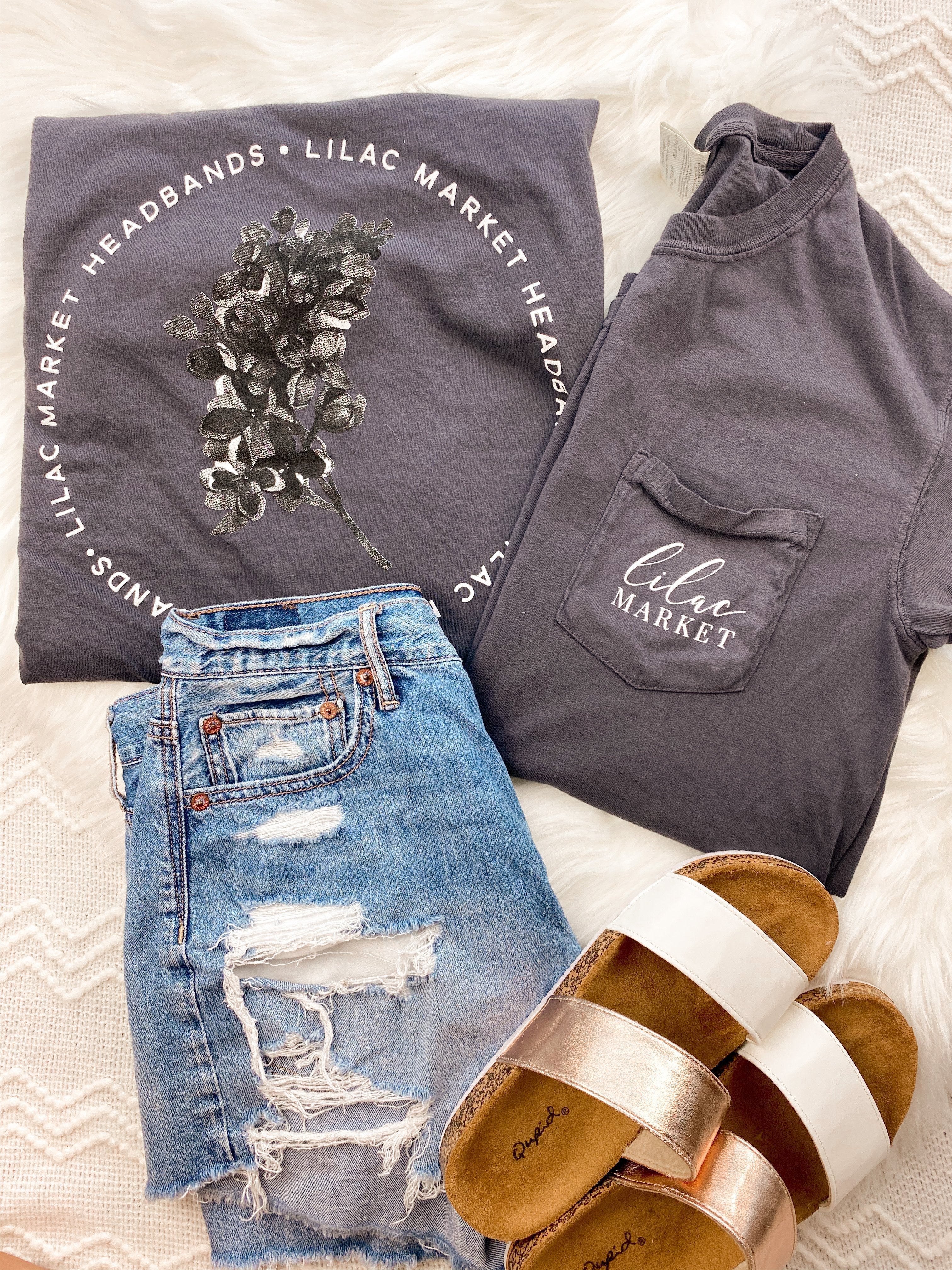 Adult grey colored shirt with grey lilac flowers with the words "Lilac Market Headbands" encircling them, and "Lilac Market" script on the front over a small pocket
