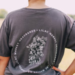 Adult grey colored shirt with grey lilac flowers with the words "Lilac Market Headbands" encircling them, and "Lilac Market" script on the front over a small pocket