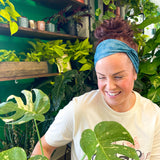 Adult women's dark teal headband with white outline of Monstera plant leaves