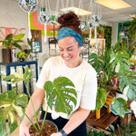 Adult women's dark teal headband with white outline of Monstera plant leaves