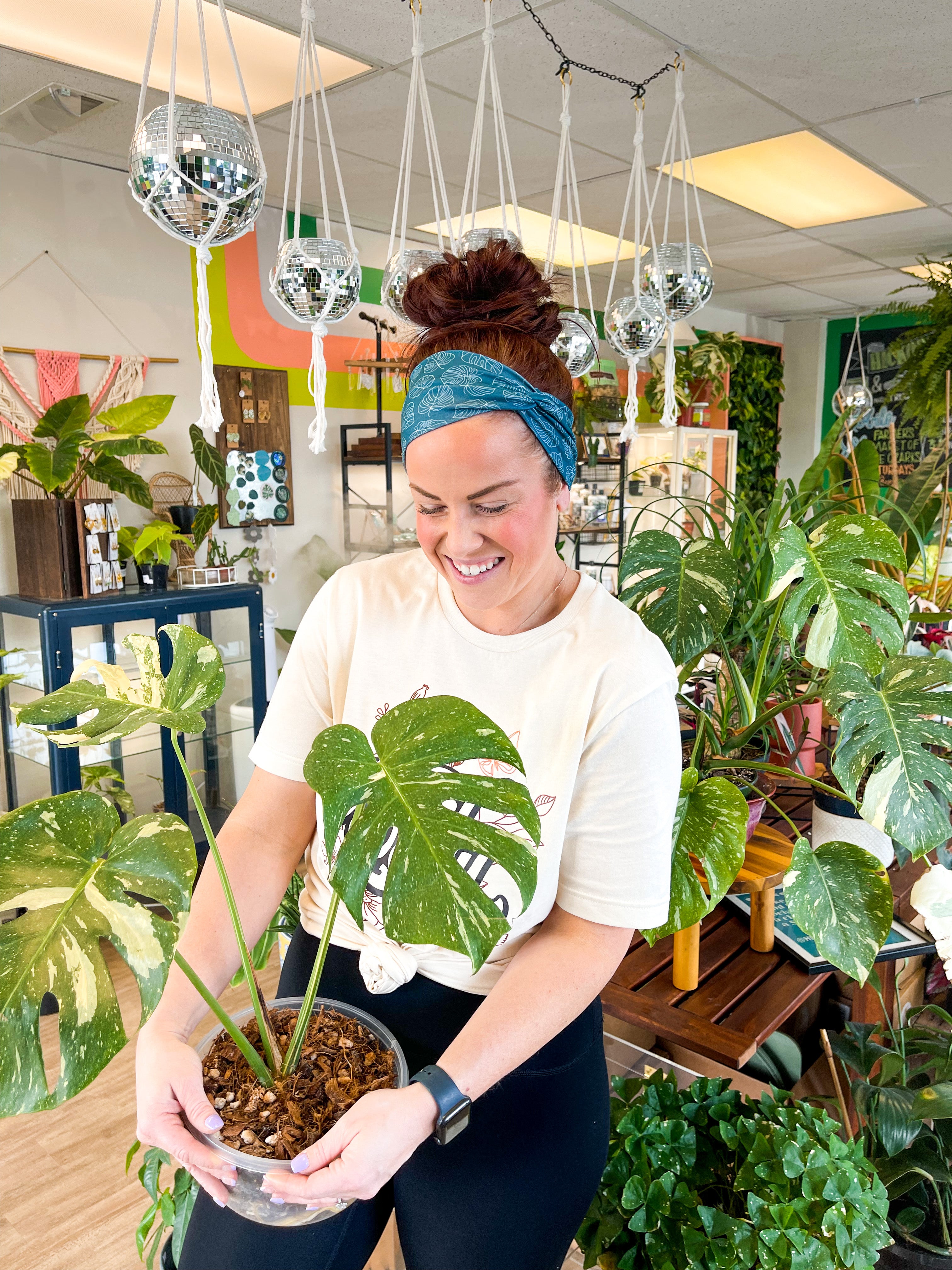 Adult women's dark teal headband with white outline of Monstera plant leaves