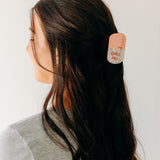 A woman with a Chill Pill Lilac Clip in her hair, showcasing the Lilac Clip - a 2.8 glossy claw clip for all hair types. Hinge closure keeps hair secure.