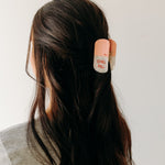 A woman with a Chill Pill Lilac Clip in her hair, showcasing the Lilac Clip - a 2.8 glossy claw clip for all hair types. Hinge closure keeps hair secure.