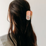 A woman with a Chill Pill Lilac Clip in her hair, showcasing the Lilac Clip - a 2.8 glossy claw clip for all hair types. Hinge closure keeps hair secure.