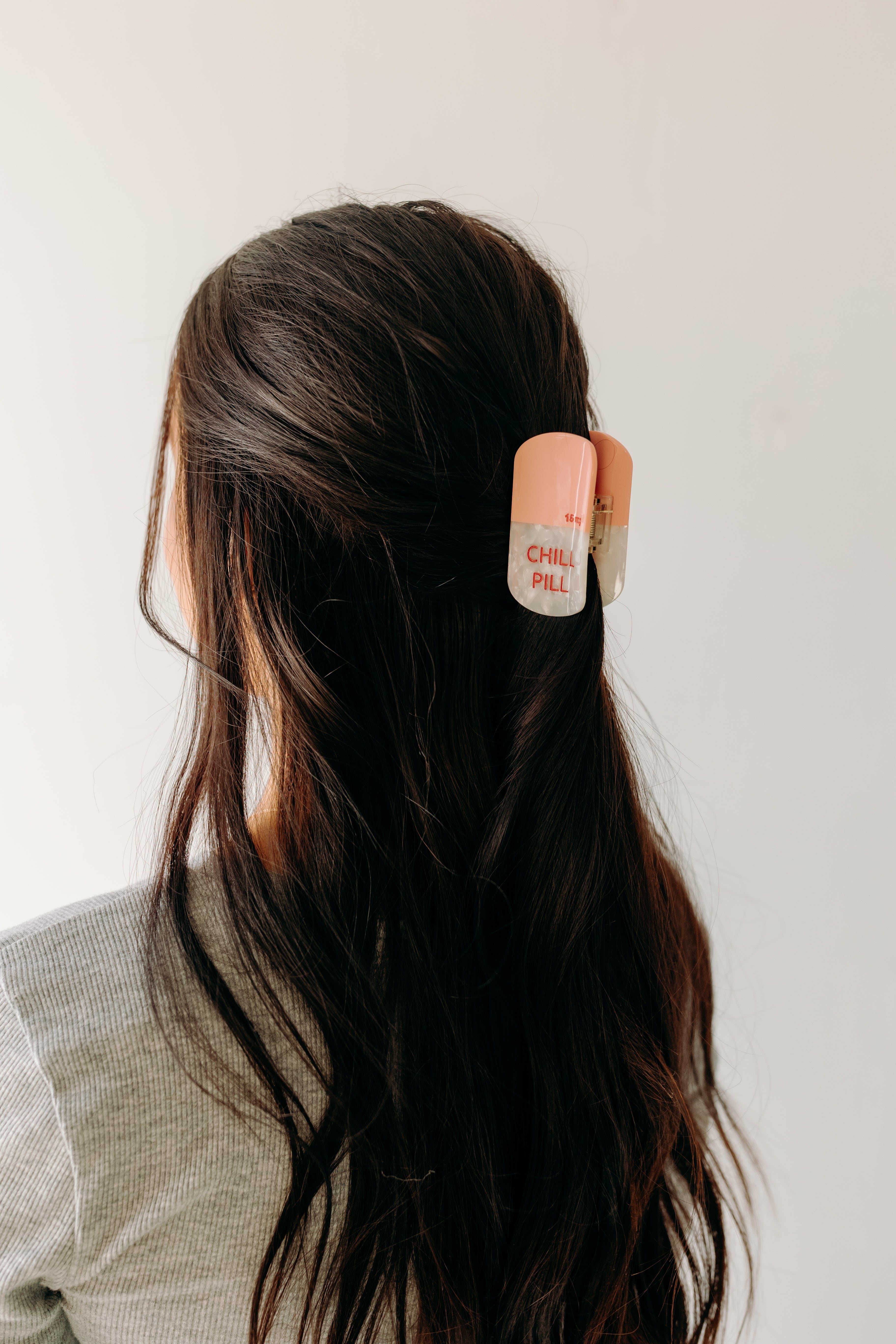 A woman with a Chill Pill Lilac Clip in her hair, showcasing the Lilac Clip - a 2.8 glossy claw clip for all hair types. Hinge closure keeps hair secure.