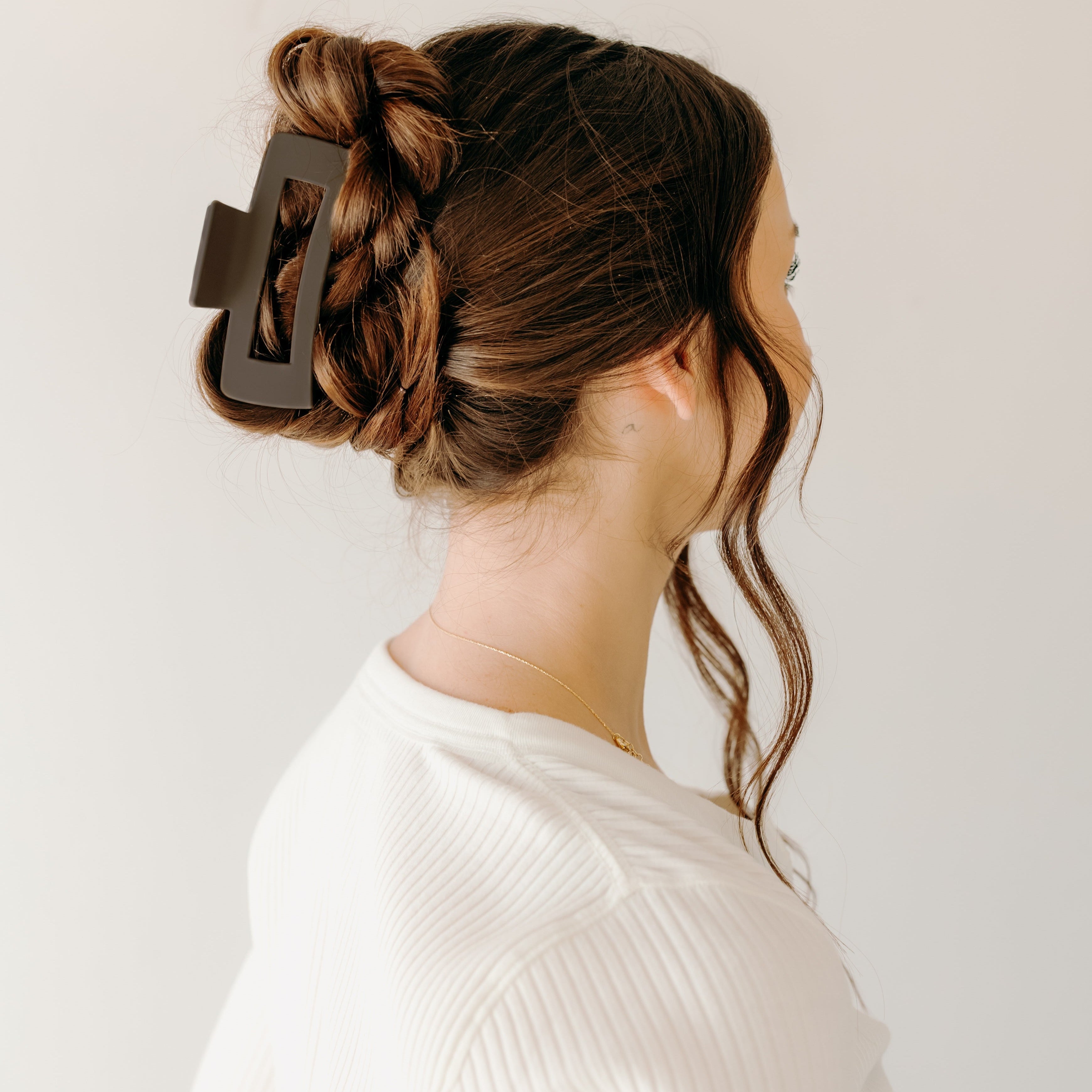 A woman wearing The Essential Lilac Clip, a hair accessory with a hinge closure, perfect for all hair types and textures.