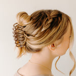Woman wearing the mocha Take It Easy Lilac Clip, hair styled in a twisted bun with the clip.
