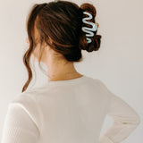 Woman wearing a light blue Comes in Waves Lilac Clip hair clip, showcasing her hairstyle.