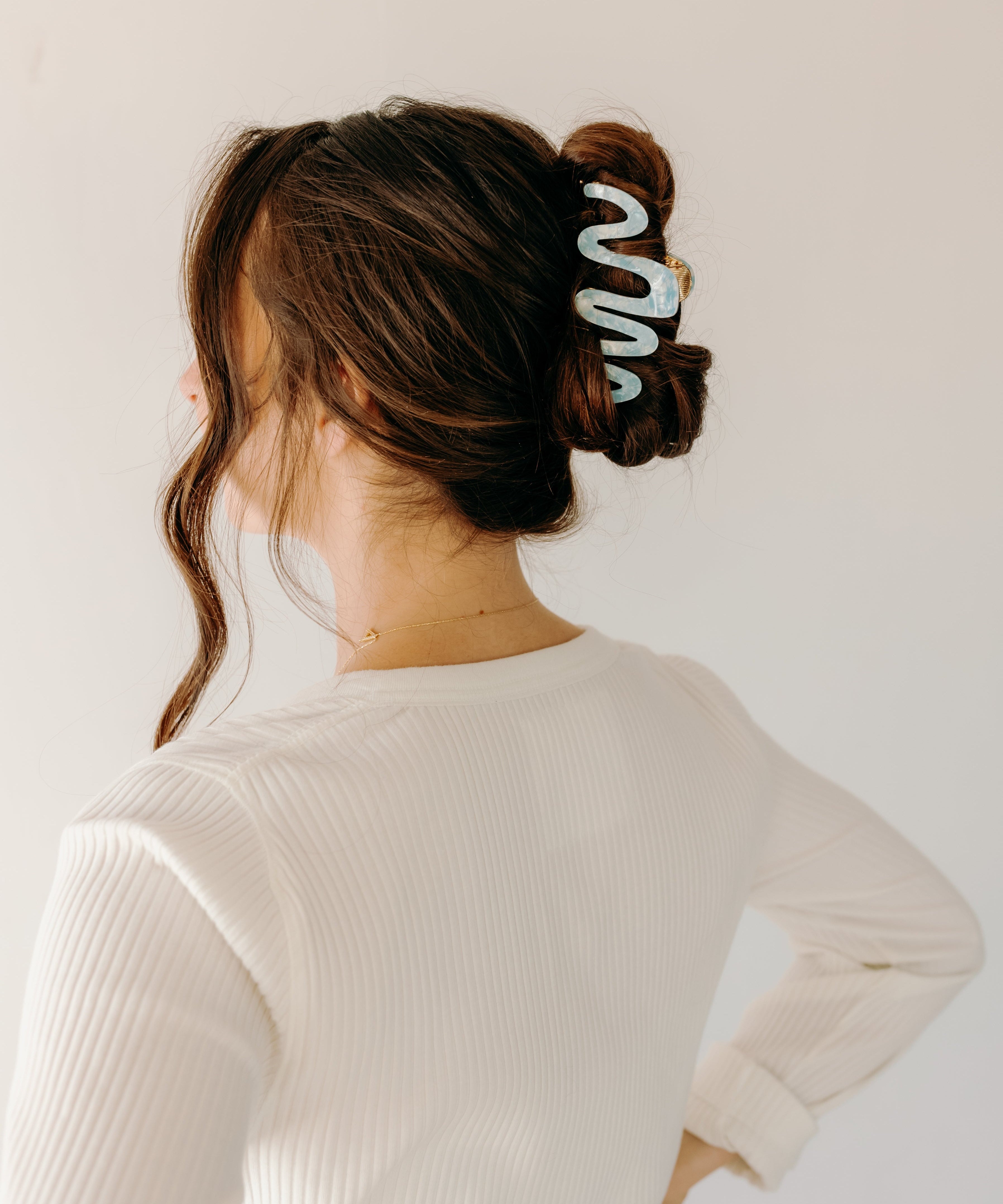 Woman wearing a light blue Comes in Waves Lilac Clip hair clip, showcasing her hairstyle.
