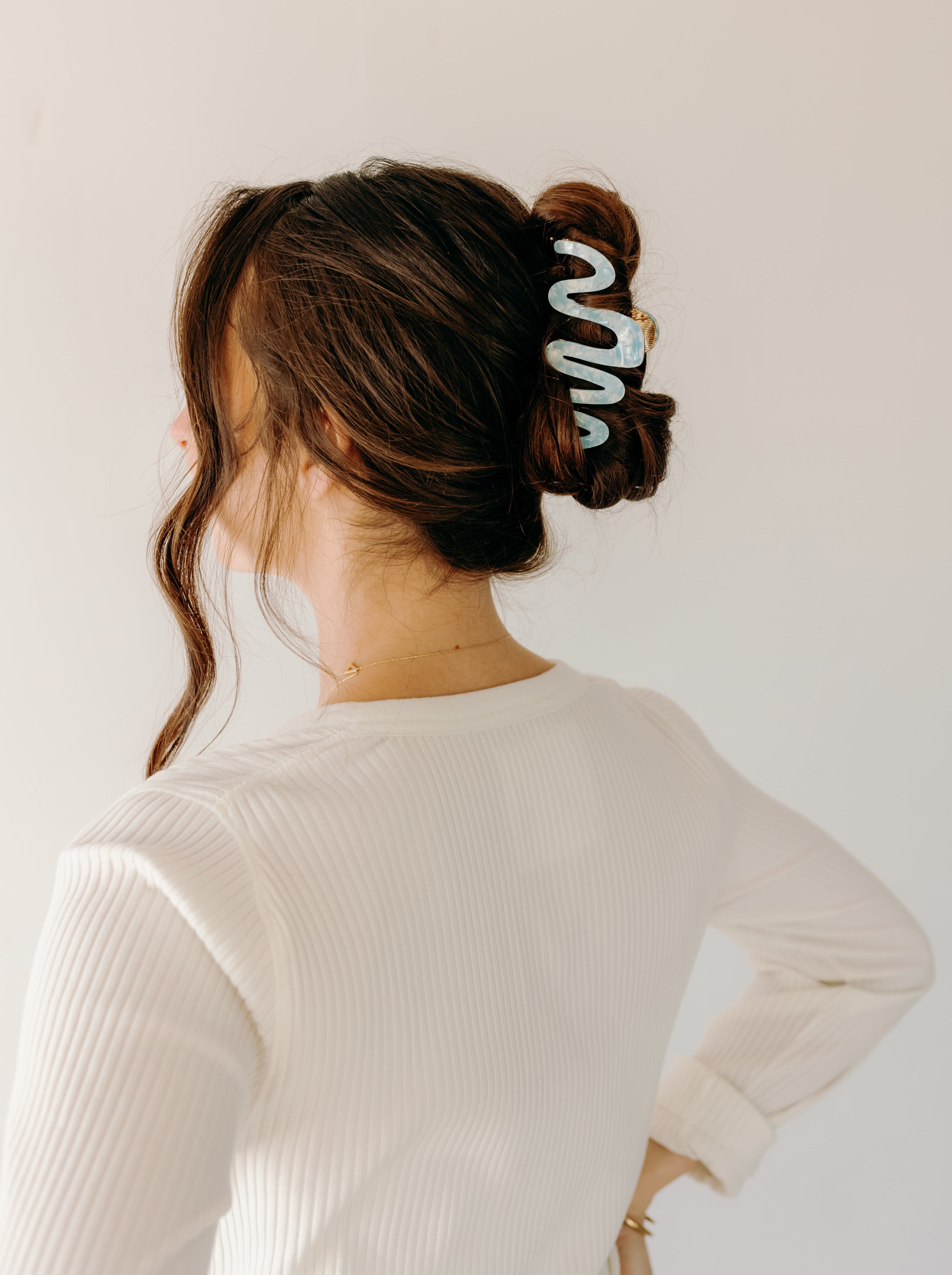 Woman wearing a light blue Comes in Waves Lilac Clip hair clip, showcasing her hairstyle.
