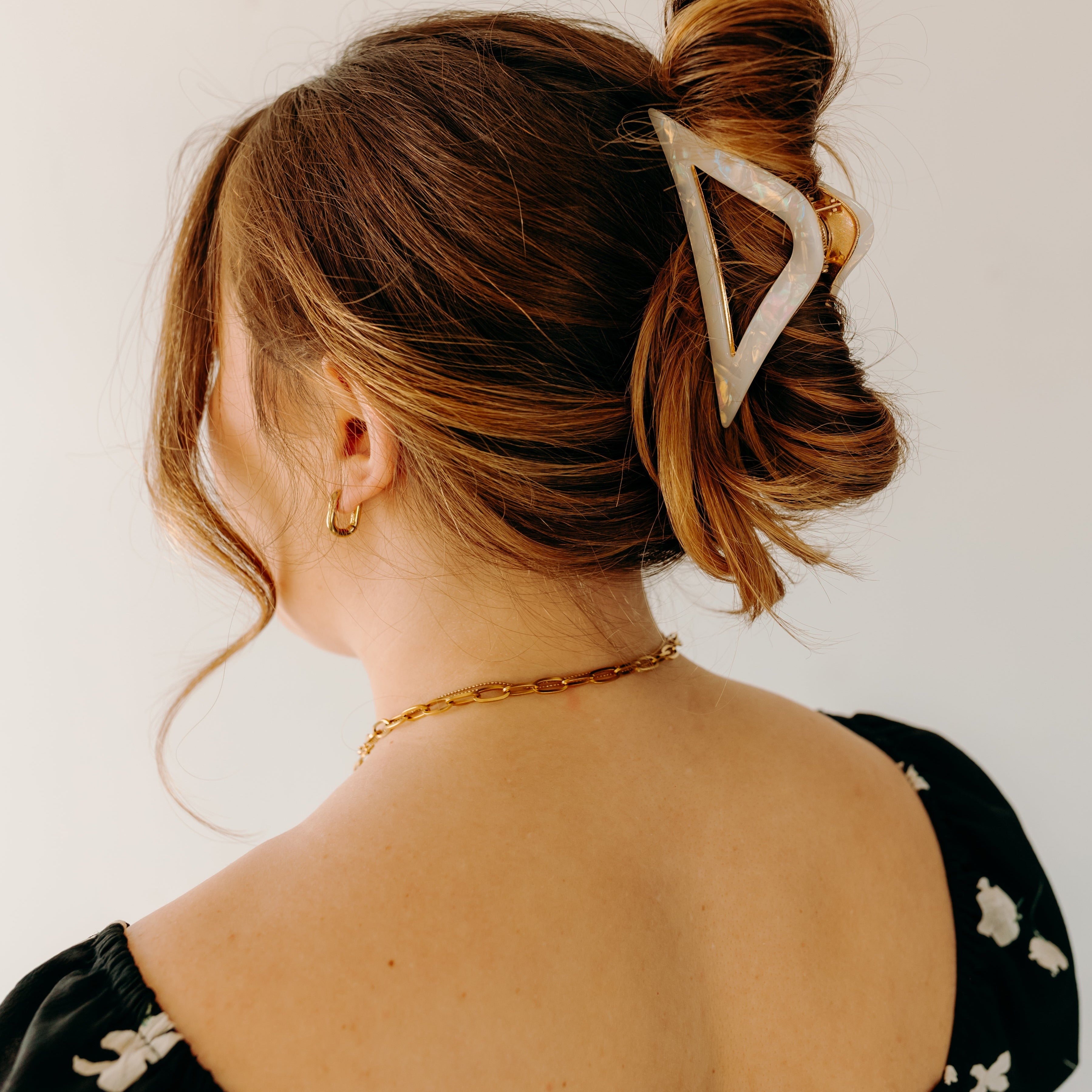 A woman with long hair wearing the A Different Angle Lilac Clip, a glossy hair accessory with a hinge closure.