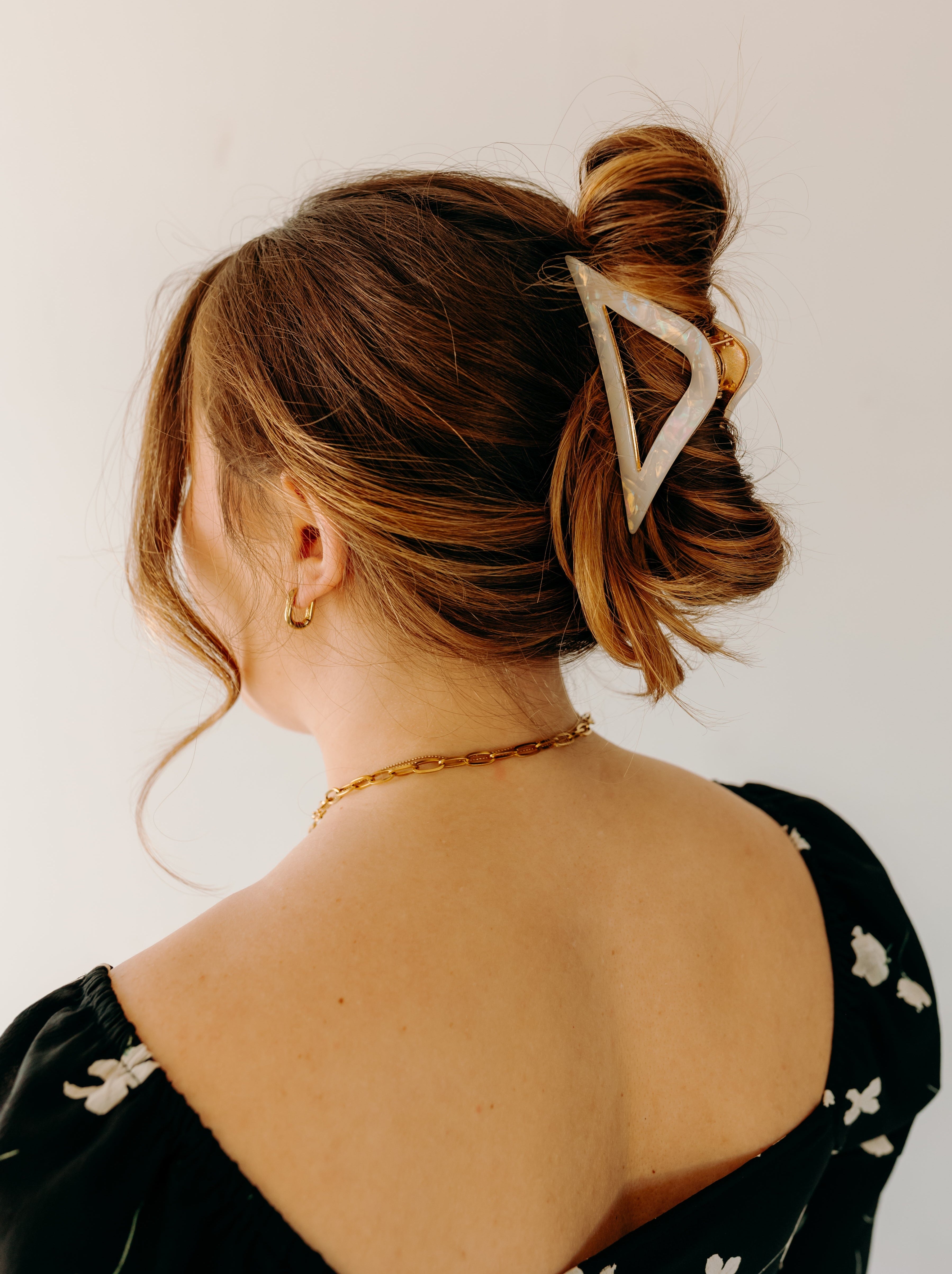 A woman with long hair wearing the A Different Angle Lilac Clip, a glossy hair accessory with a hinge closure.