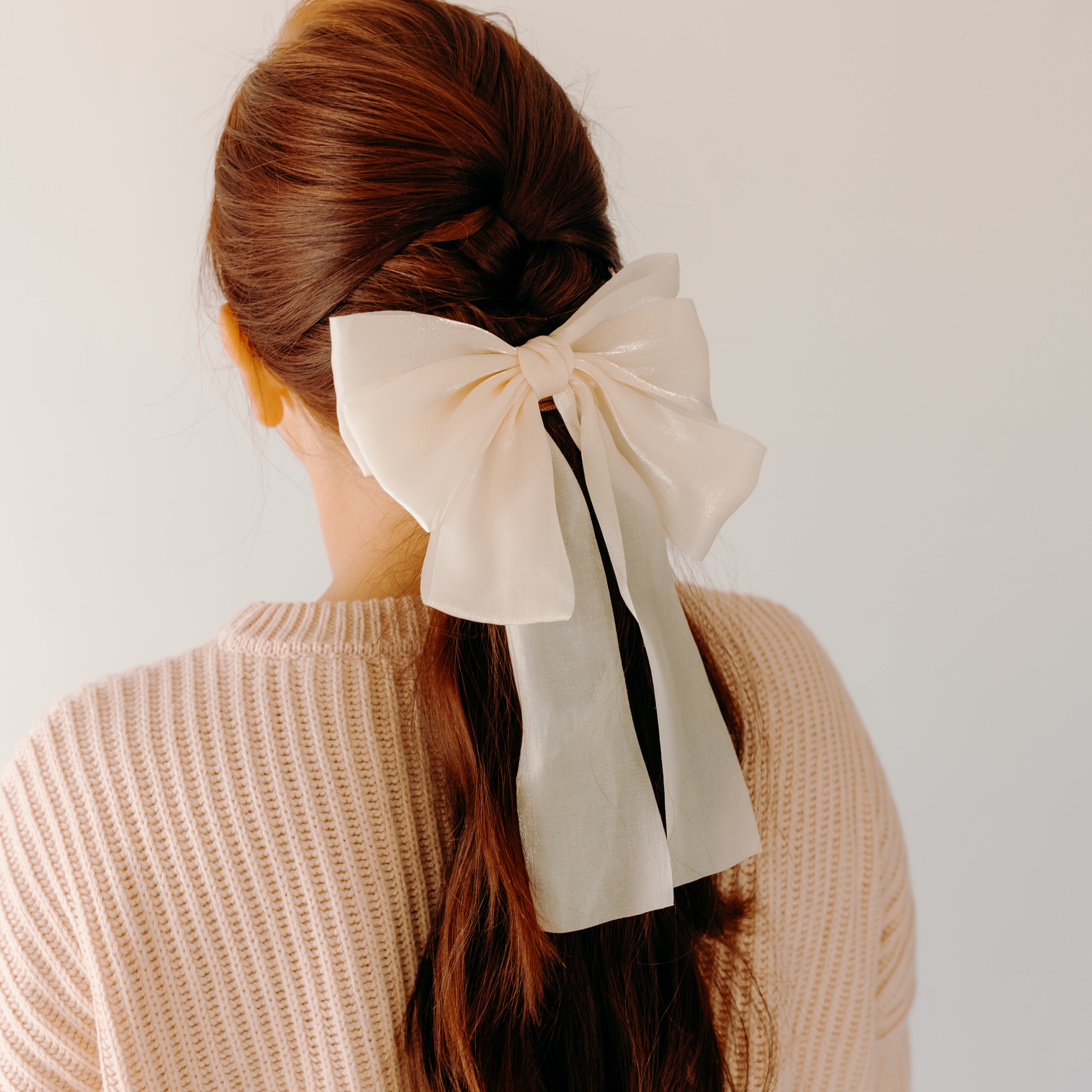 Woman wearing Say Less Lilac Clip with ivory bow, a cute fashion accessory.
