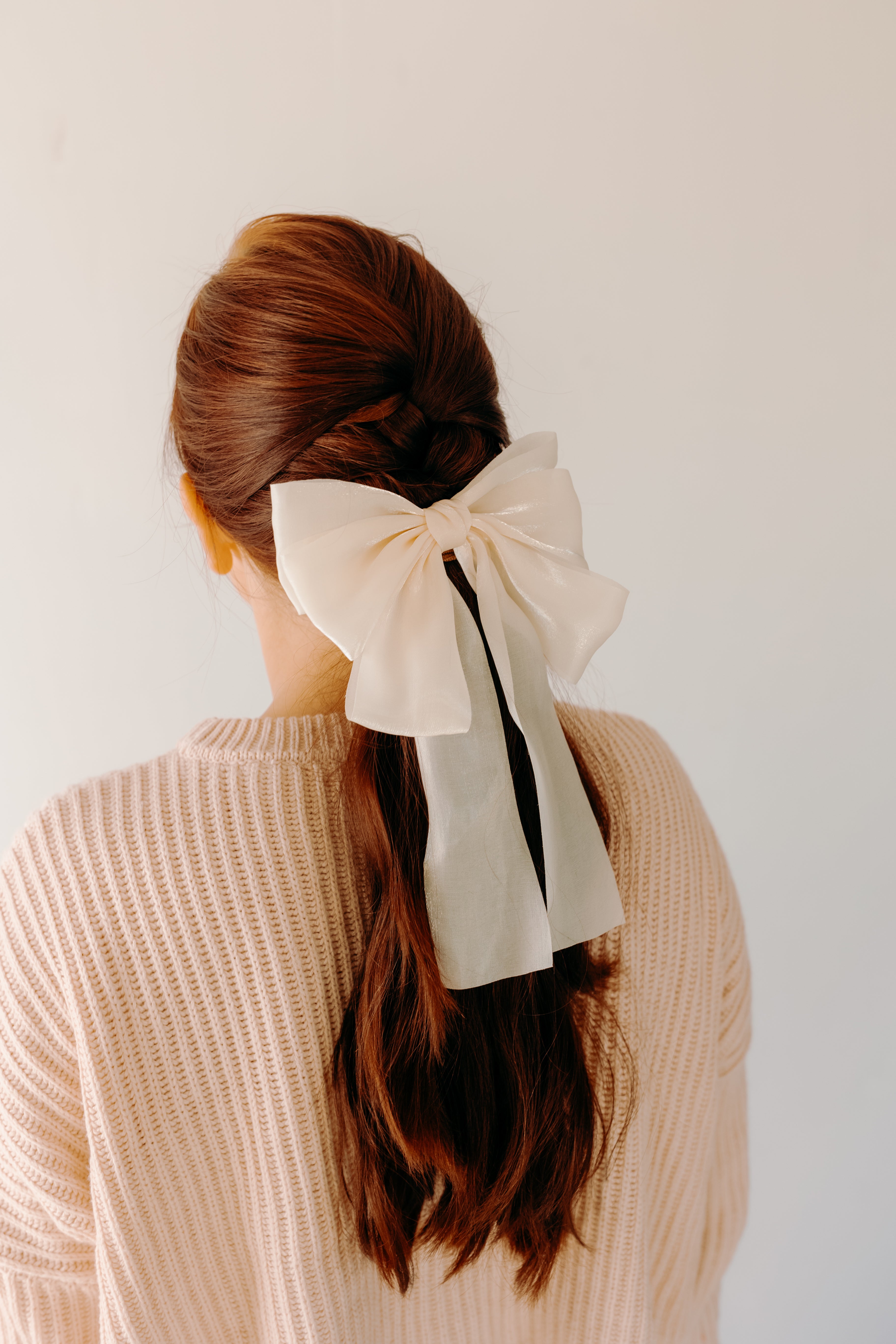 Woman wearing Say Less Lilac Clip with ivory bow, a cute fashion accessory.