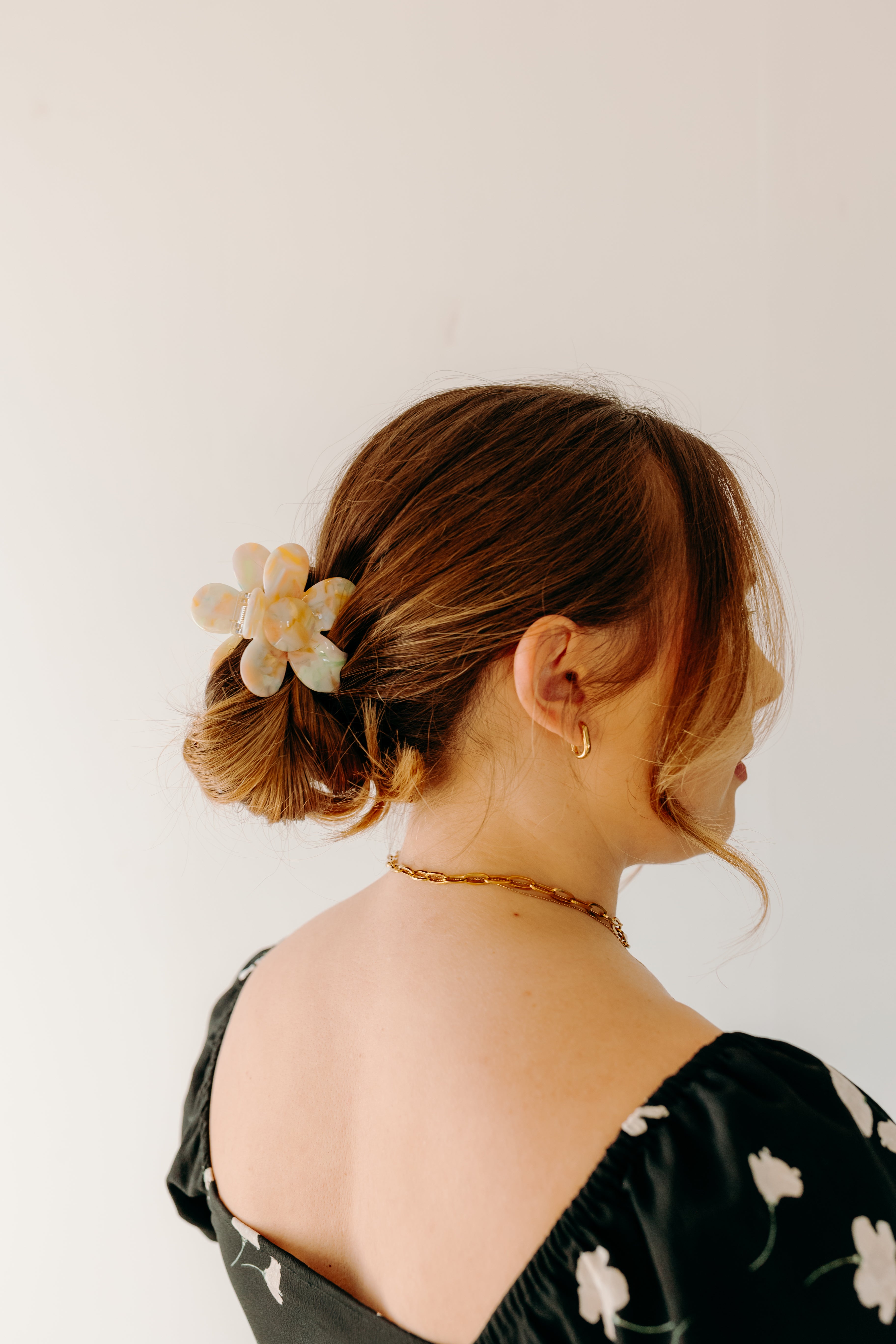 Woman wearing Time to Bloom Lilac Clip in her hair, close-up of flower hair accessory.