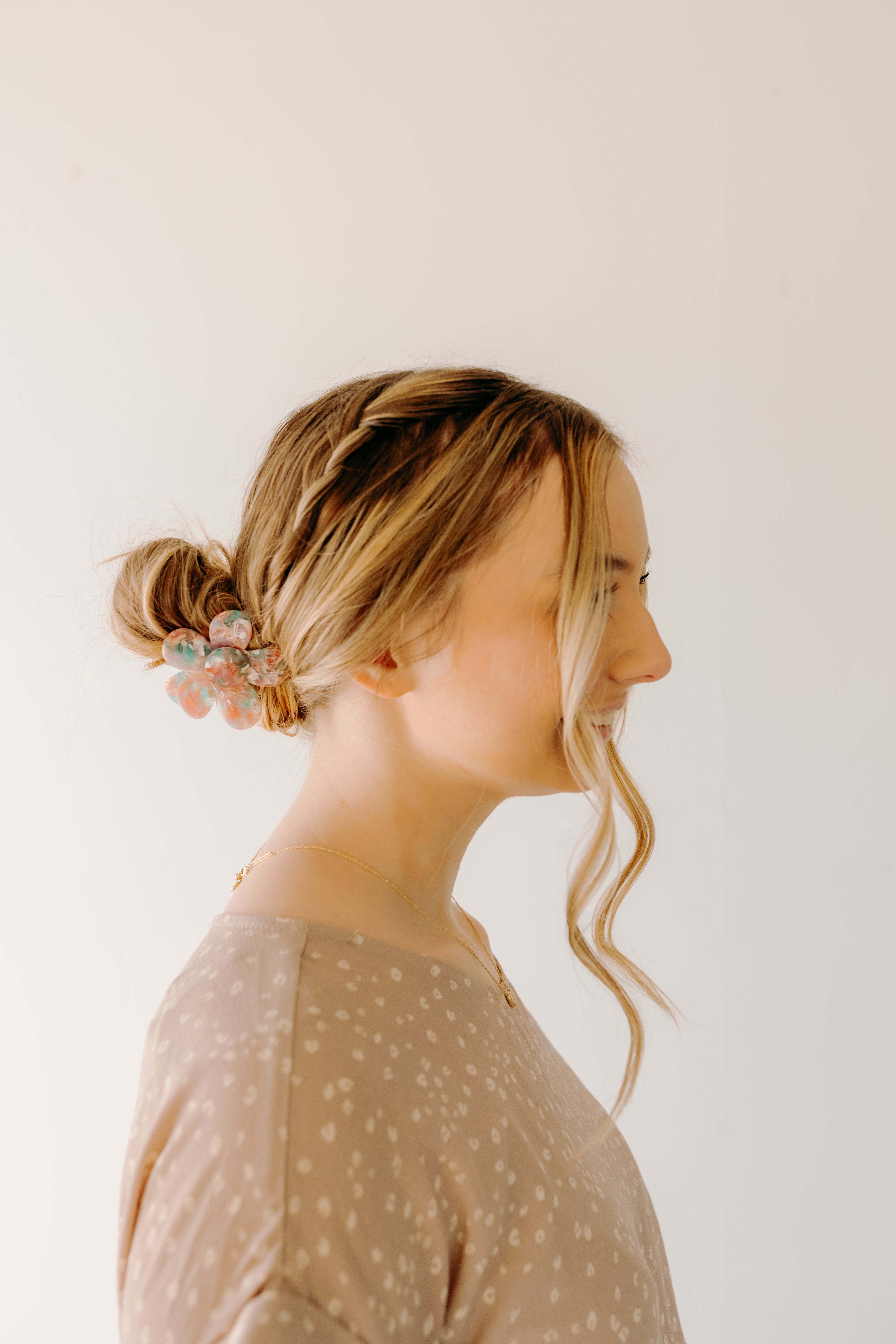 Woman wearing Time to Bloom Lilac Clip in her hair, close-up of flower hair accessory.