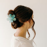 Woman wearing Time to Bloom Lilac Clip in her hair, close-up of flower hair accessory.
