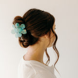 Woman wearing Time to Bloom Lilac Clip in her hair, close-up of flower hair accessory.
