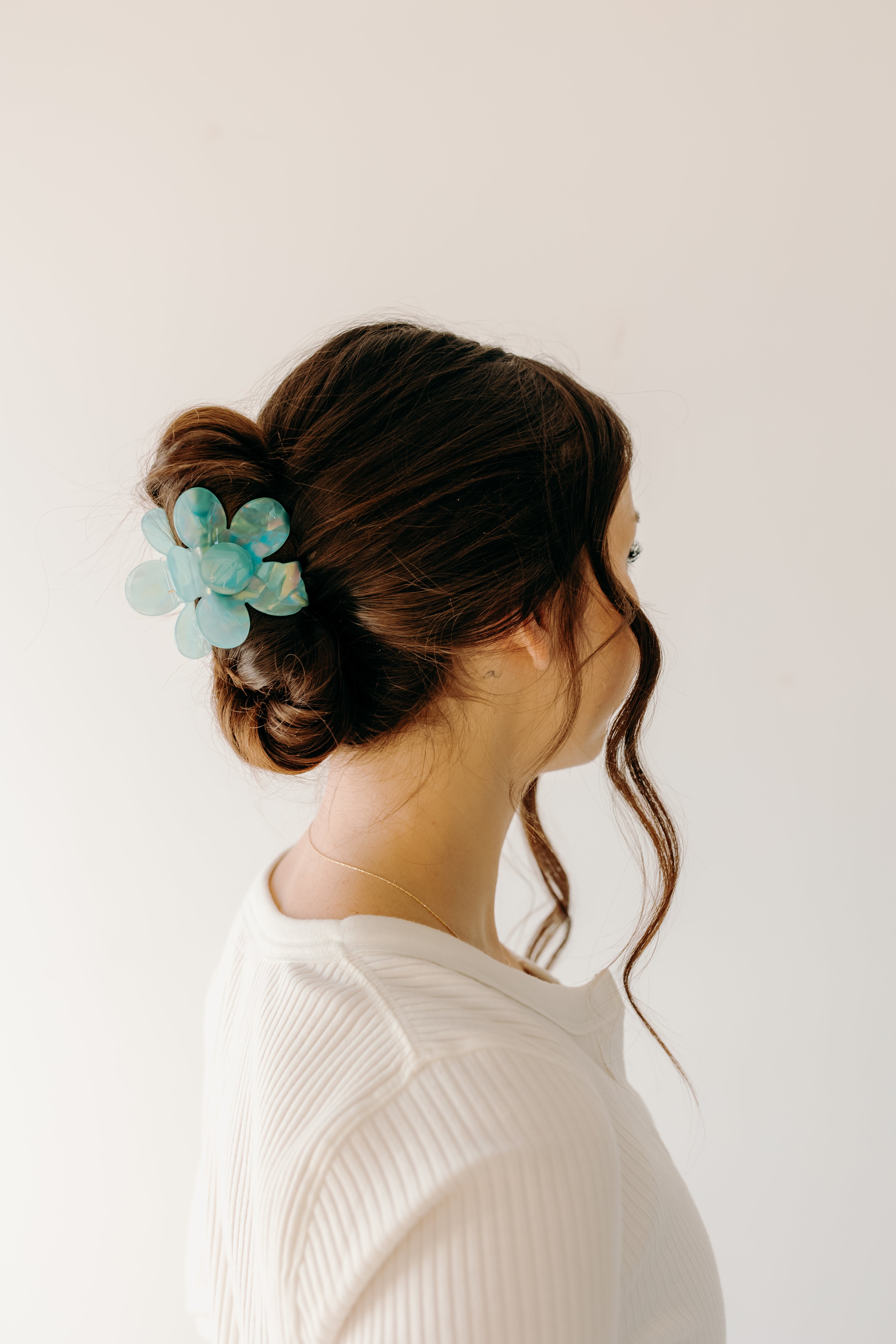 Woman wearing Time to Bloom Lilac Clip in her hair, close-up of flower hair accessory.