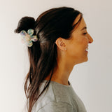 Woman wearing Time to Bloom Lilac Clip in her hair, close-up of flower hair accessory.
