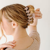 A woman with long hair showcasing the Simply Twisted Lilac Clip. Matte material, 5.5 inches long, with a hinge closure.
