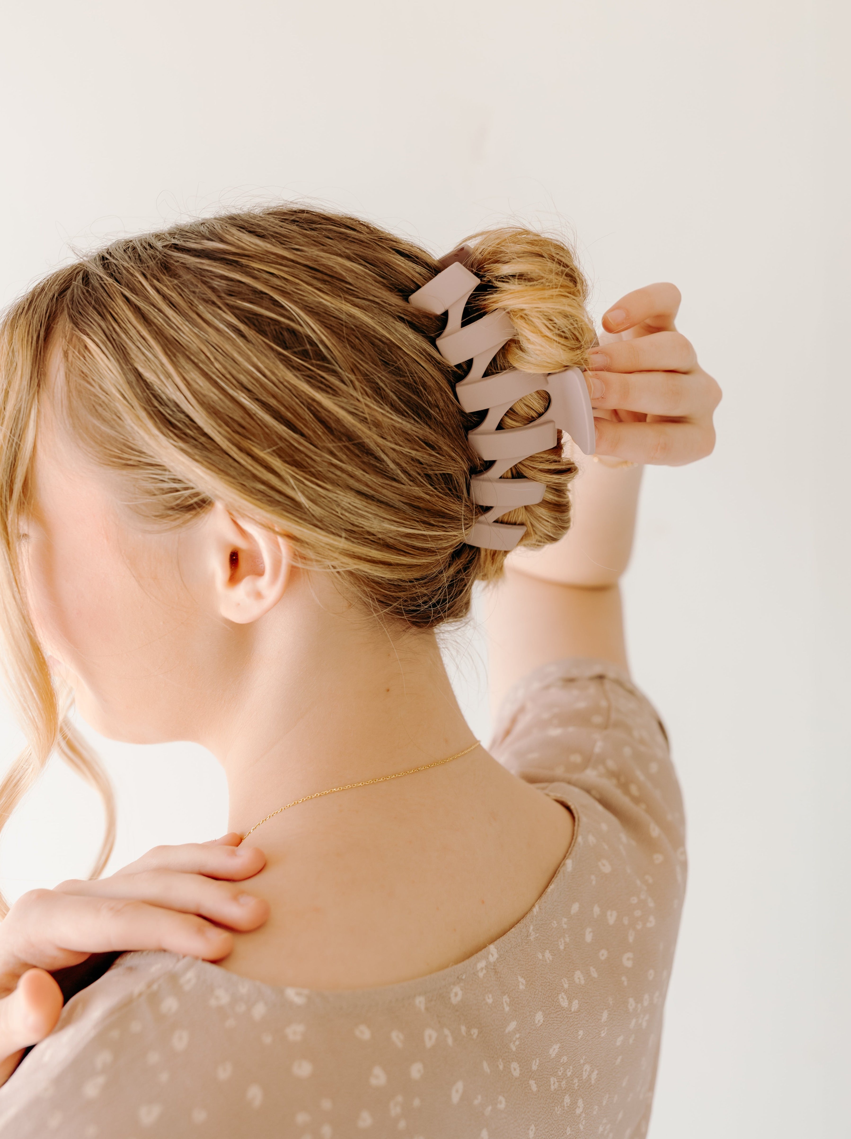 A woman with long hair showcasing the Simply Twisted Lilac Clip. Matte material, 5.5 inches long, with a hinge closure.