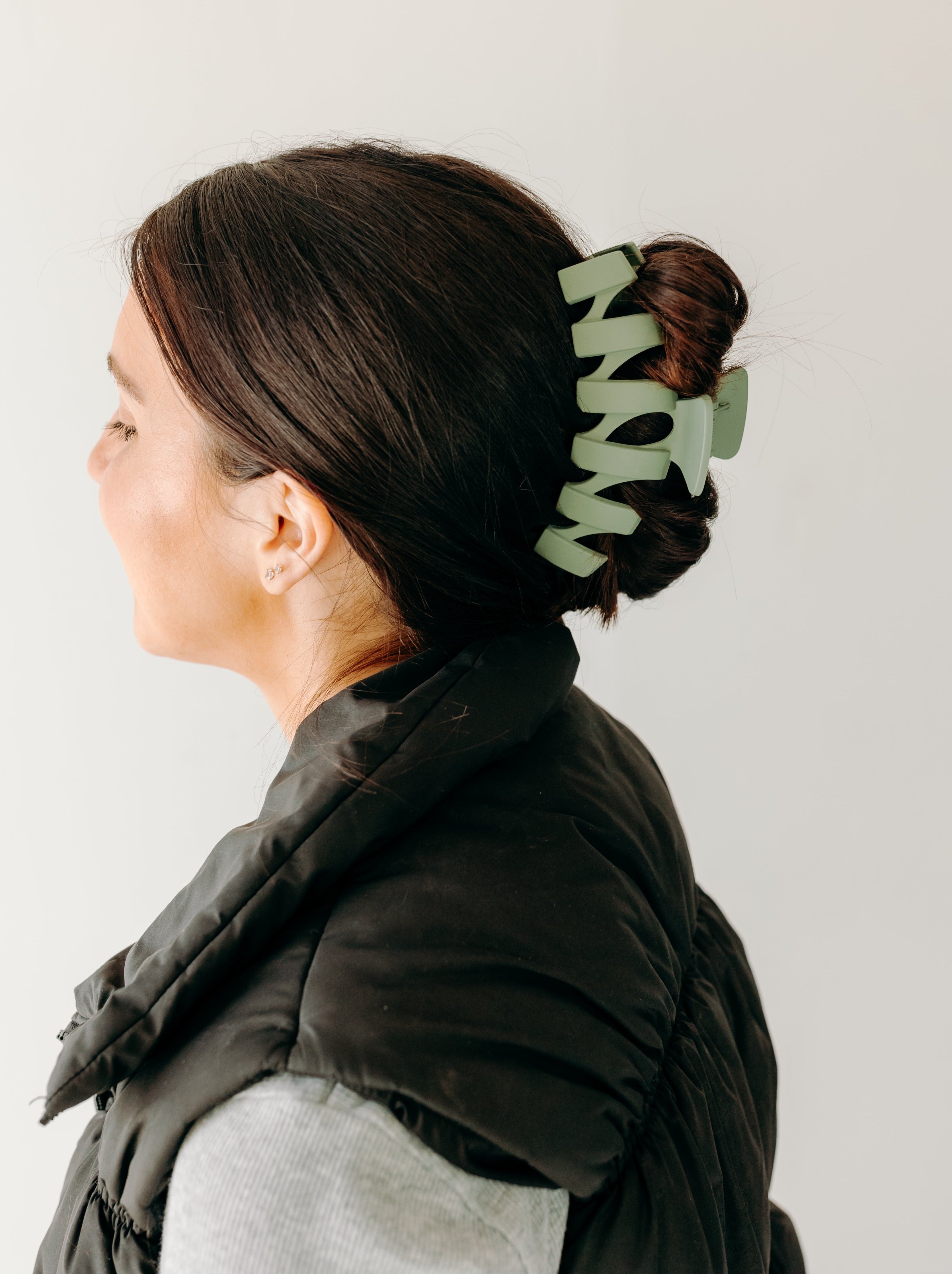 A woman with long hair showcasing the Simply Twisted Lilac Clip. Matte material, 5.5 inches long, with a hinge closure.