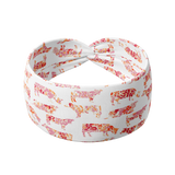 You Herd Me white headband with pink, red and orange floral cow pattern, featuring a knot design. Ultra-stretchy, non-slip poly-knit blend, perfect for workouts, long shifts, or playdays.