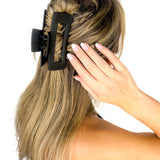 A woman wearing The Essential Lilac Clip, a hair accessory with a hinge closure, perfect for all hair types and textures.