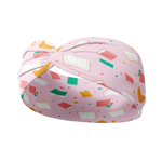 A pink Book Fairy headband featuring a book and star pattern, designed for confidence and functionality. Lilac Market's Book Fairy headband offers a versatile 3-in-1 twist style, sweat-absorbent fabric, and a non-slip fit. Made in Springfield, MO.