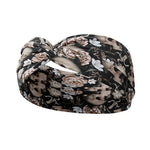 Adult women's black headband with allover artisticly painted human skulls, white peony flowers, other smaller white flowers and butterflies