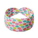 Adult women's white headband with bright purple, pink, teal, coral and purple smiley faces and tiny stars