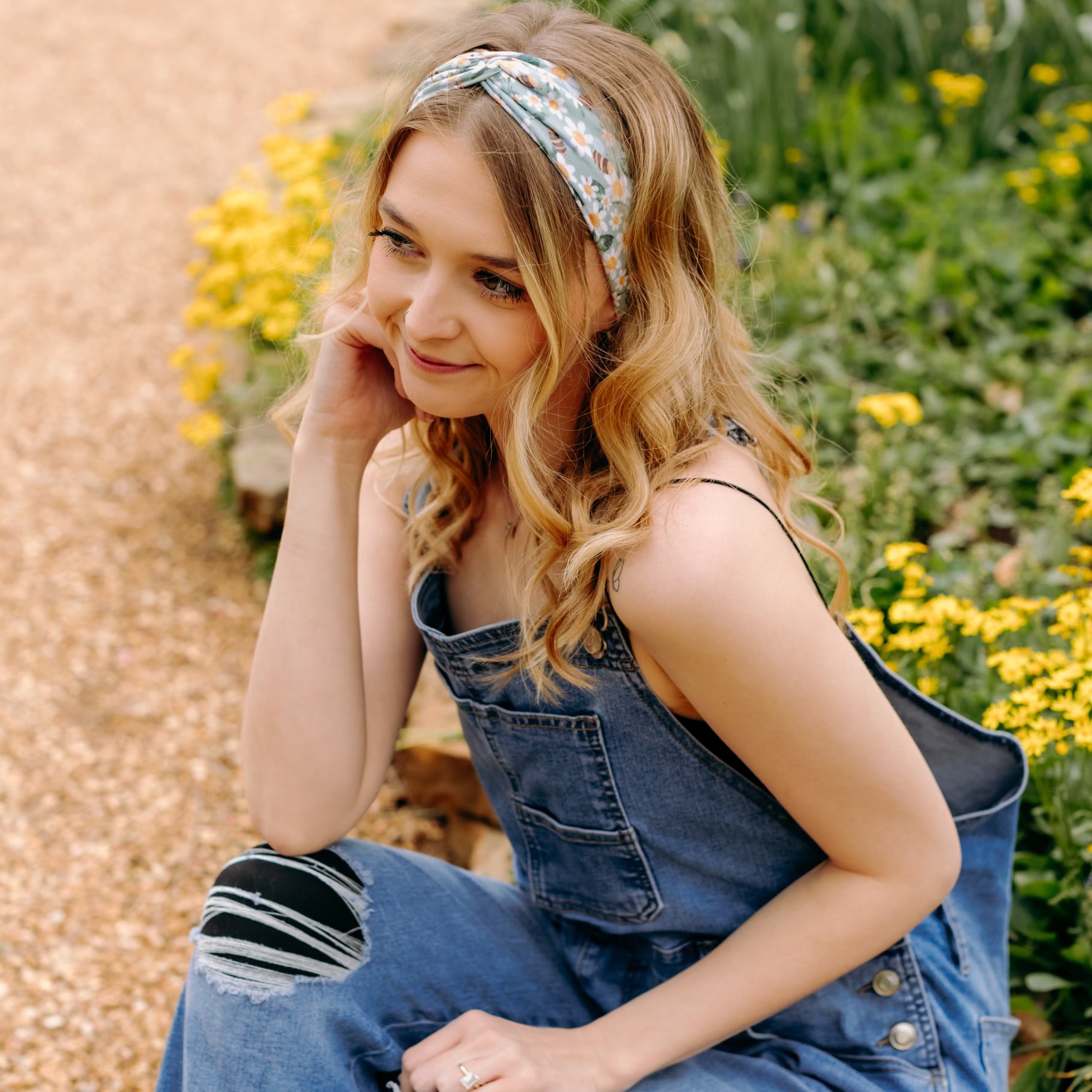 A woman in Lilac Market's Blossom Buddies headband smiles, showcasing its versatile 3-in-1 twist style. Functional, machine washable, and sweat-absorbent for workouts or play.
