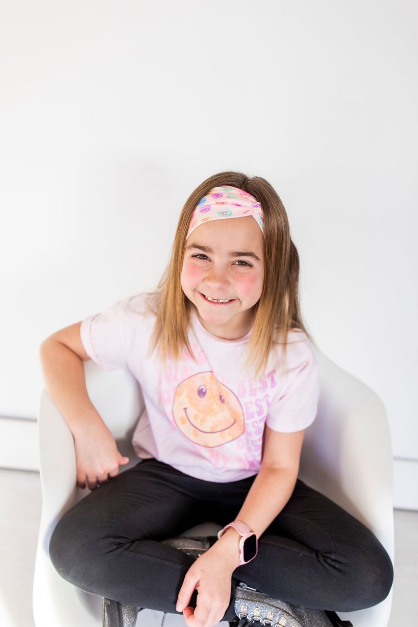 Adult women's peach headband with purple, blue, orange, yellow, green and pink candy hearts with various Valentine's sayings