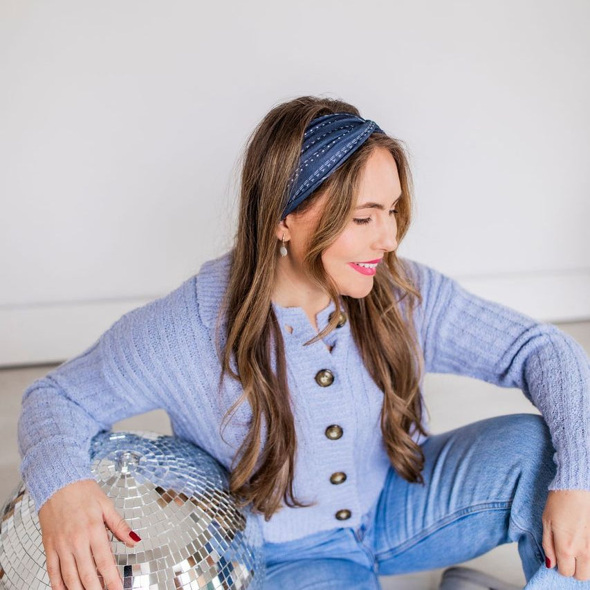 Adult women's black headband with allover stripes made up of dots, arrows and dashes