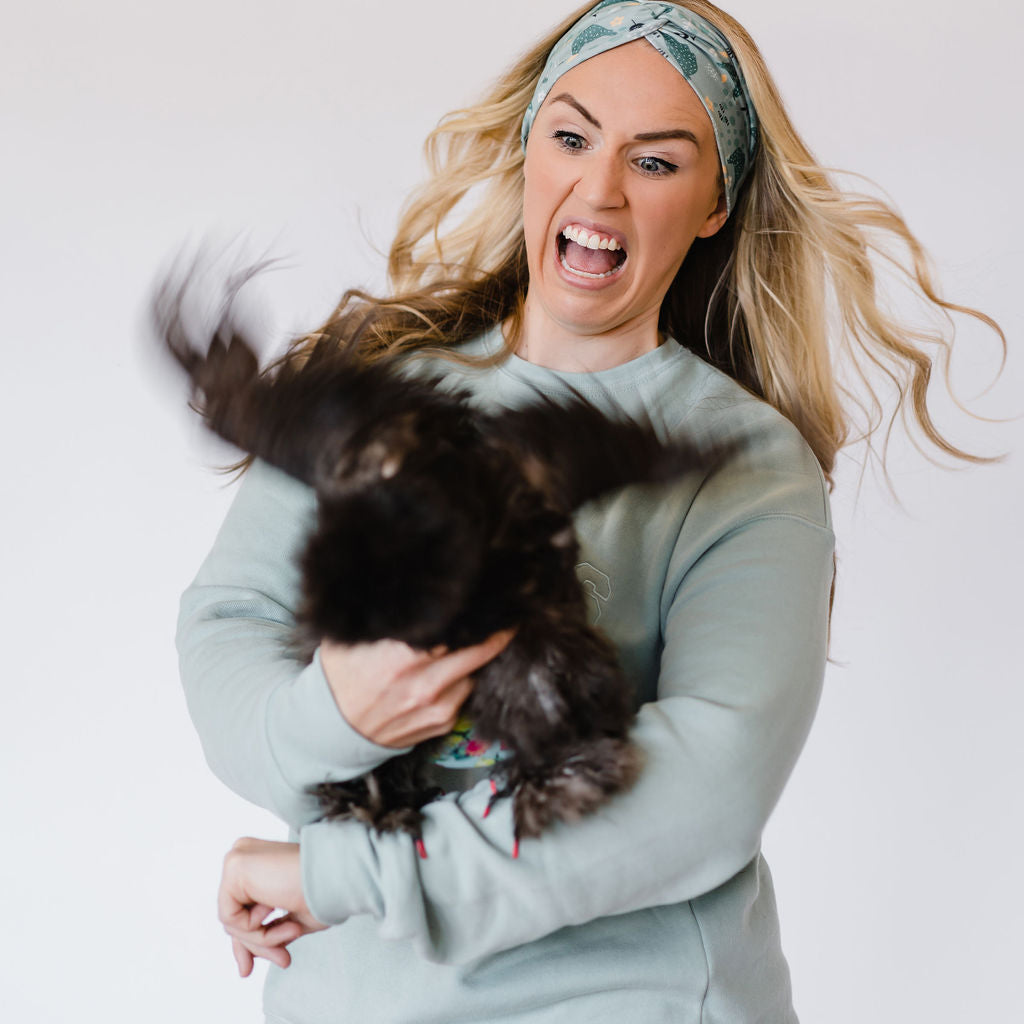 Adult women's teal headband with small yellow and white flowers and teal hand-drawn chickens pecking the ground